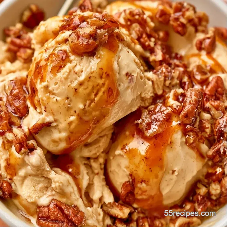 Three velvety scoops of beige frozen dessert in a glass bowl, garnished with toasted nuts and a cinnamon dusting.